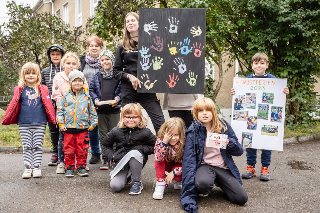 Die Ferienkinder präsentieren ihre Erinnerungsstücke – Handabdrücke und eine Fotovollage.