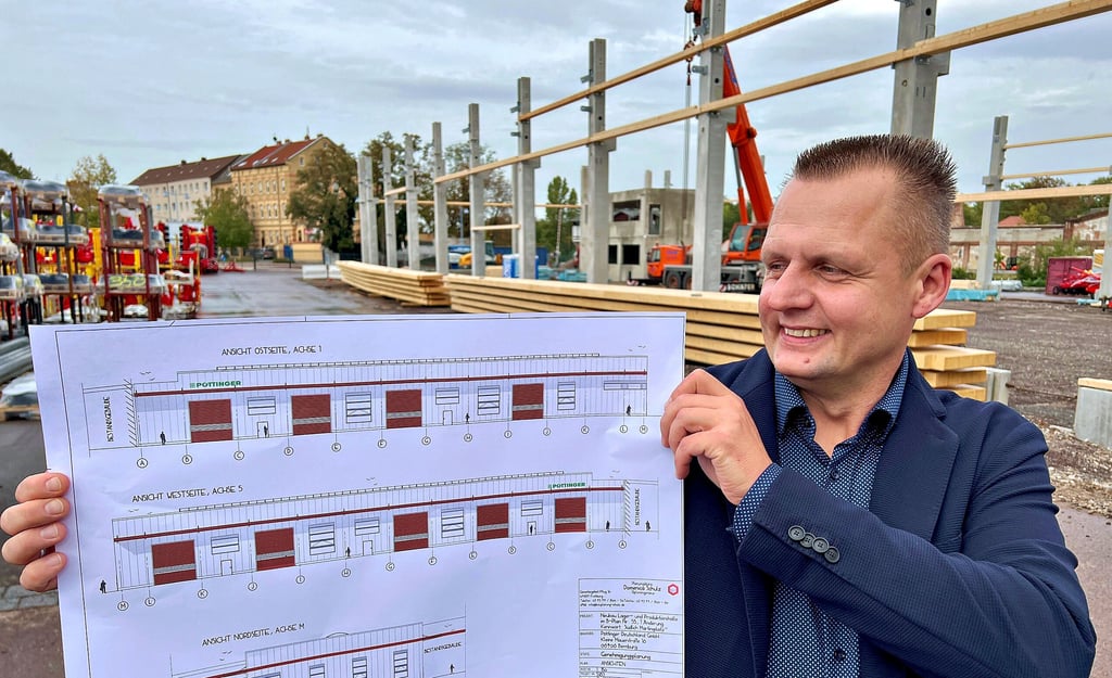 Steffen Wöhler ist neuer Werkleiter bei Pöttinger in Bernburg und zeigt den Plan für den Hallenneubau, der gerade entsteht.