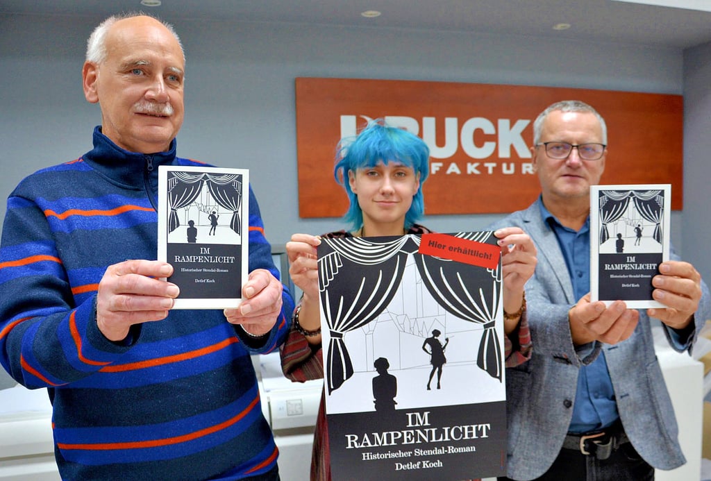Autor Detlef Koch (links), Druck-Manufaktur-Inhaber Hartmut Holz und seine Praktikantin Léo Potinier aus Frankreich stellen den neuen Roman „Im Rampenlicht“ vor, der im Stendal der 1920er Jahre spielt.
