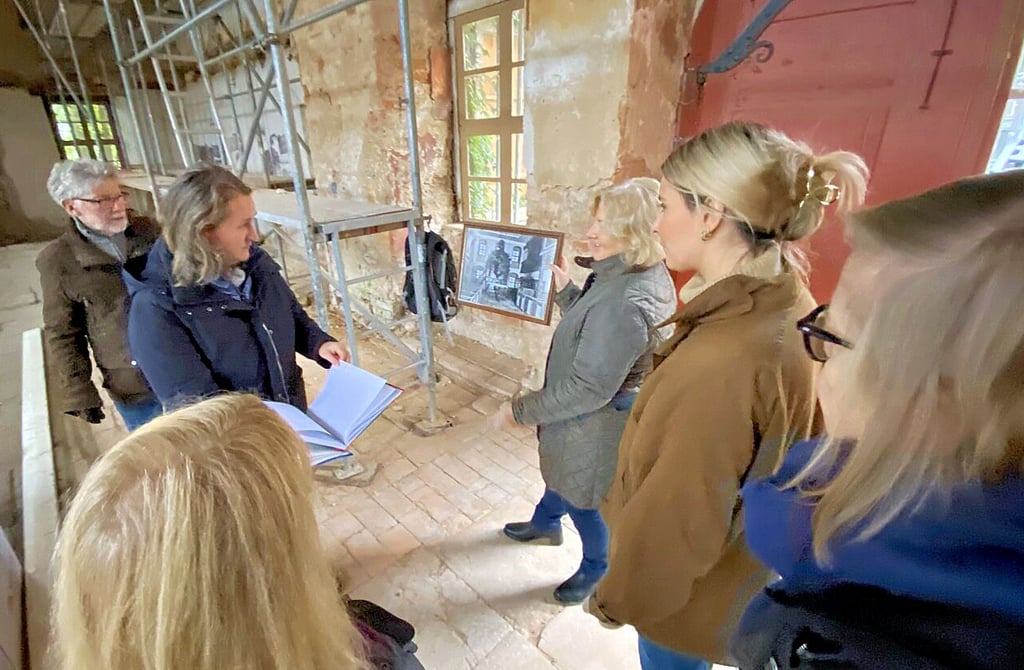 Ines Köhler zeigt ihren Gästen eine historische Ansicht der Kapelle, bevor sie nach dem Krieg zerstört wurde.