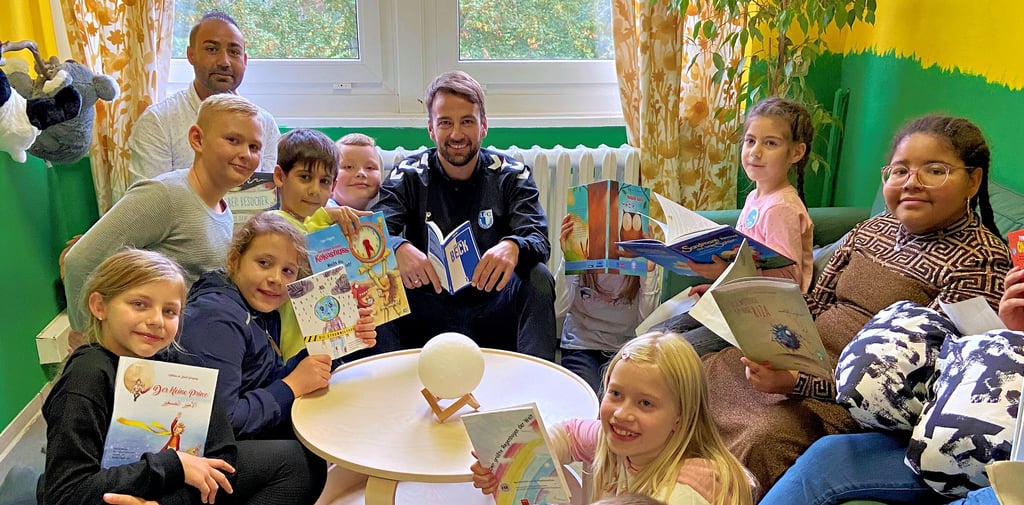 Der Hort „Weltentdecker“ in Magdeburg eröffnet zwei Leseräume. Fußballer Christian Beck ist zu Besuch und liest gemeinsam mit den Schülern.