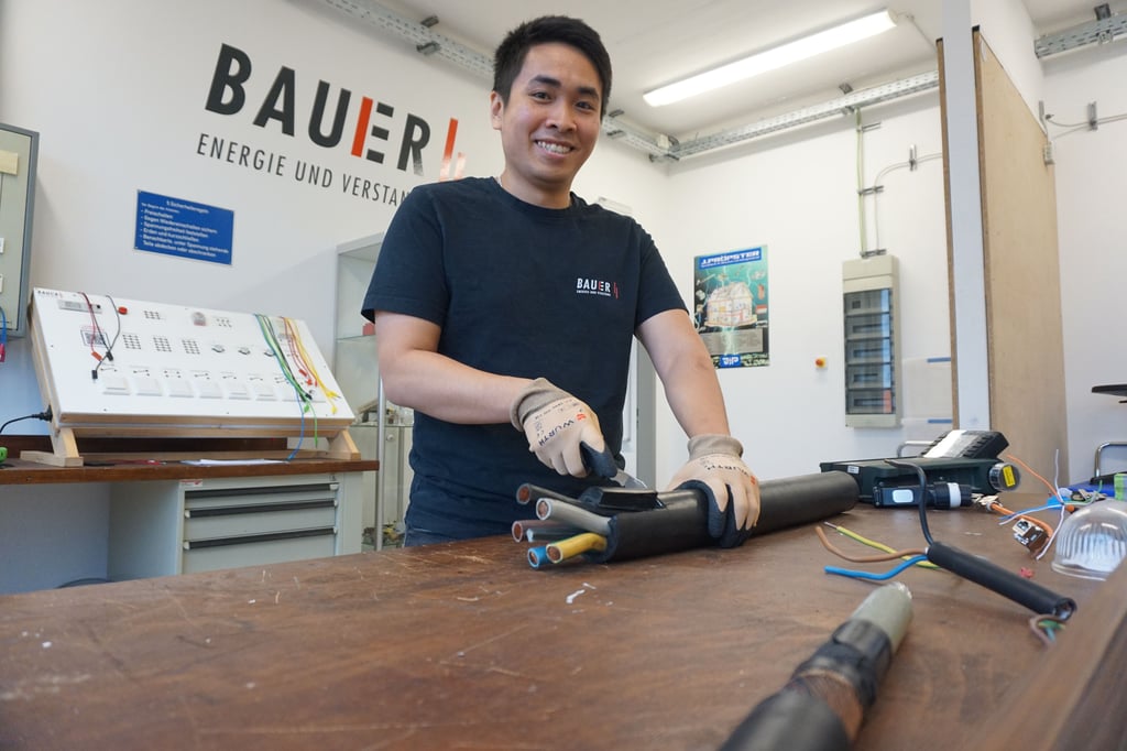 In der Lehrwerkstatt in Halle übt Anh Minh Tran das Abisolieren eines Kabelstrangs. Der Vietnamese hat schon zuvor auf Baustellen gearbeitet.