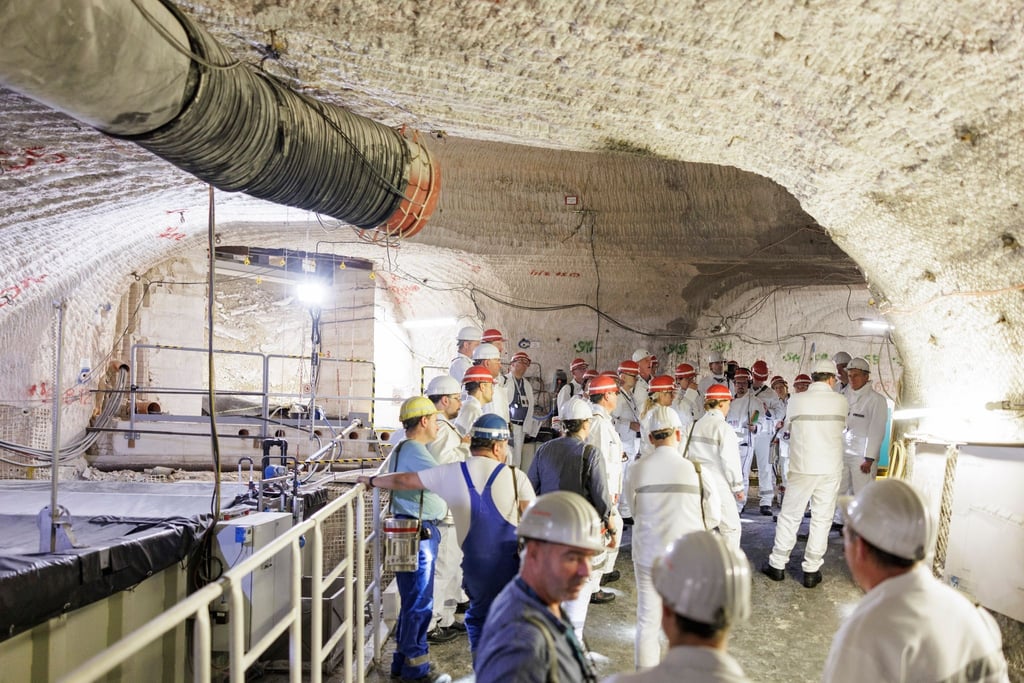 Besucher stehen im Atommülllager Asse neben einem Sammelbecken für radioaktiv belastete Lauge.