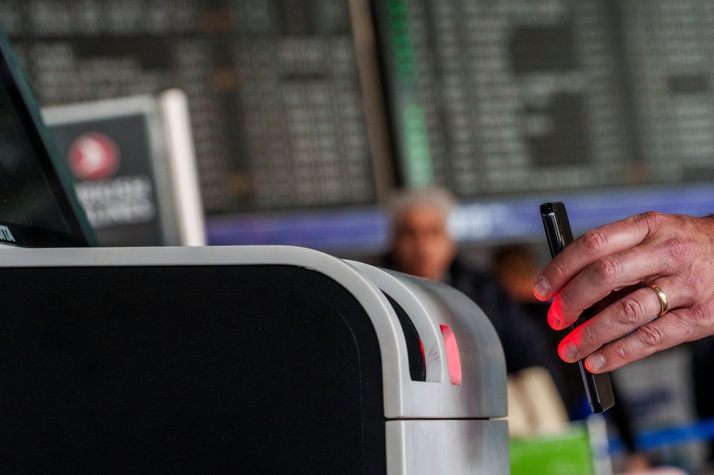 Ein QR-Code mit Reisedaten wird vom Scanner des Check-in-Automaten gelesen.