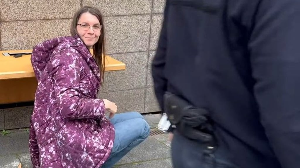 Klimakleberin Martha Krumpeck hat sich erst im Gerichtssaal festgeklebt - und wurde dann mitsamt Tisch an der Hand herausgetragen.