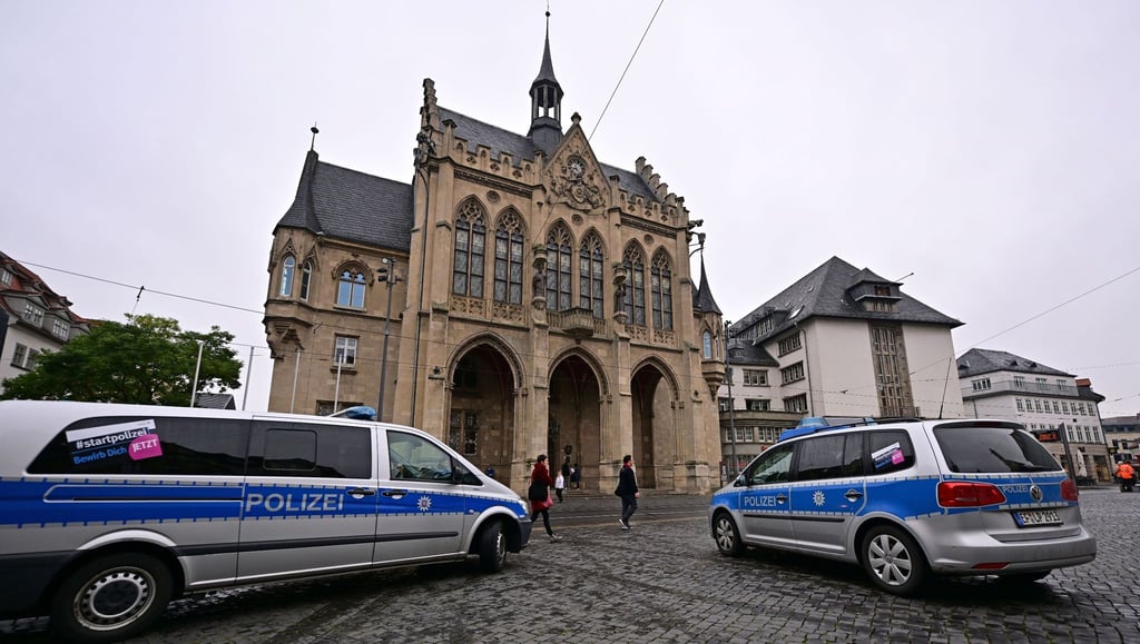 Polizeifahrzeuge stehen nach einer Bombendrohung vor dem Erfurter Rathaus.
