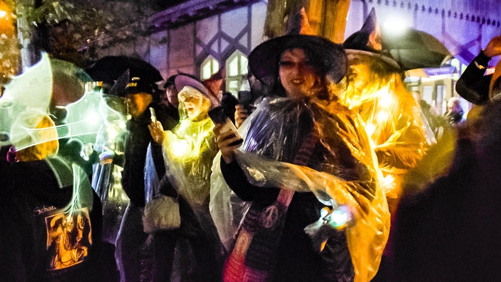 Der Regen macht ihnen nichts aus: Hexen mit Regencapes säumen den Straßenrand beim Umzug.