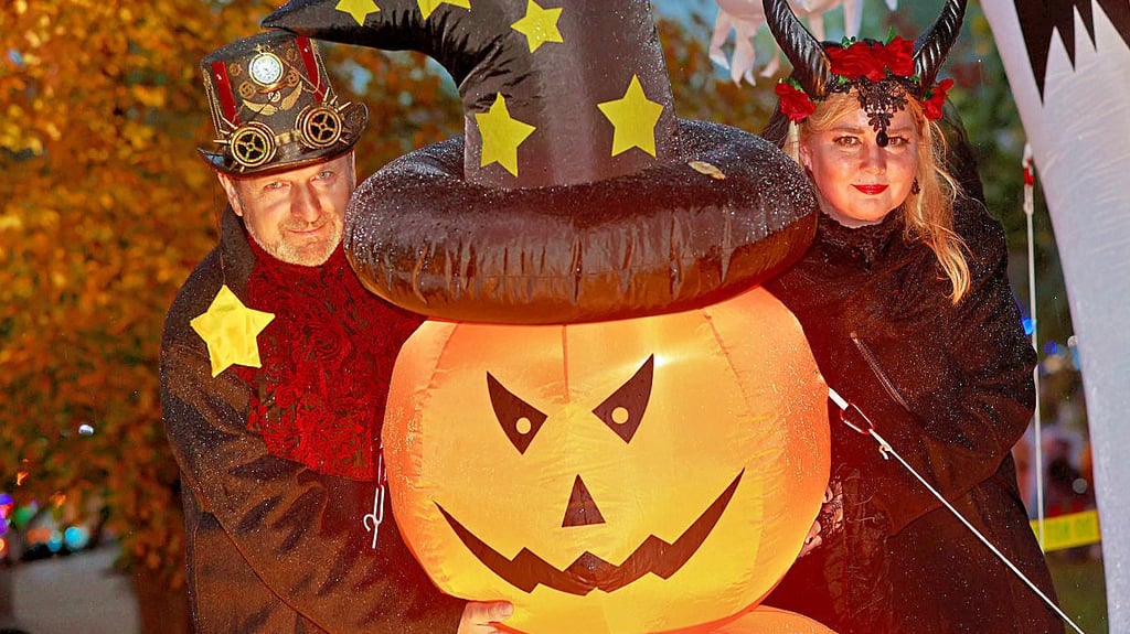 Mit dem dämonisch blickenden Kürbis lassen sich diese beiden kostümierten Besucher ablichten. 