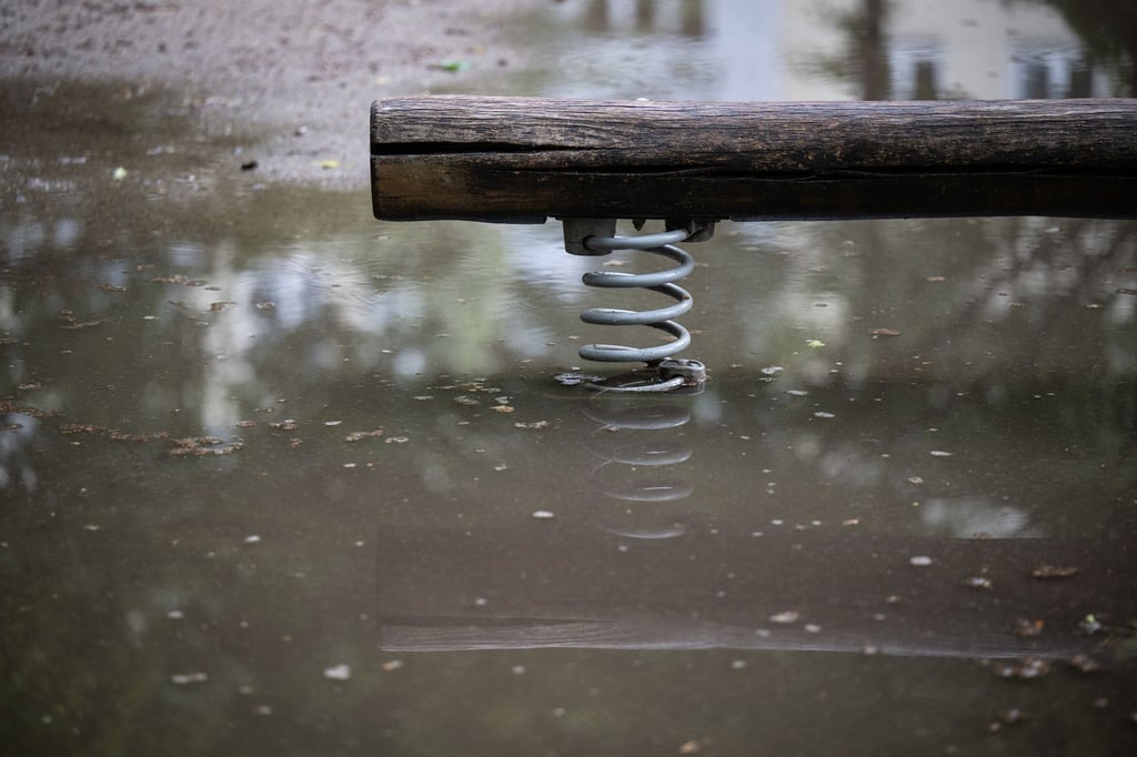 Eine Wippe auf einem Spielplatz steht im Wasser.