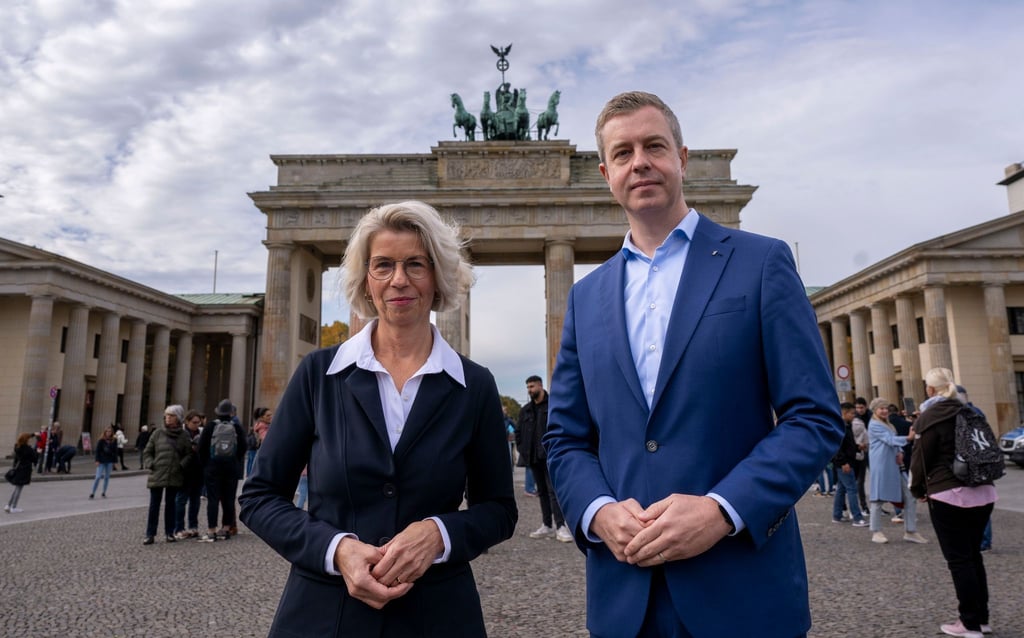 Stefan Evers und Birgit Möhring stehen vor dem Brandenburger Tor.