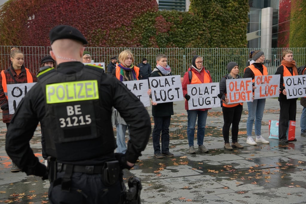 Aktivisten der Gruppe Letzte Generation stehen mit Plakaten am Kanzleramt.