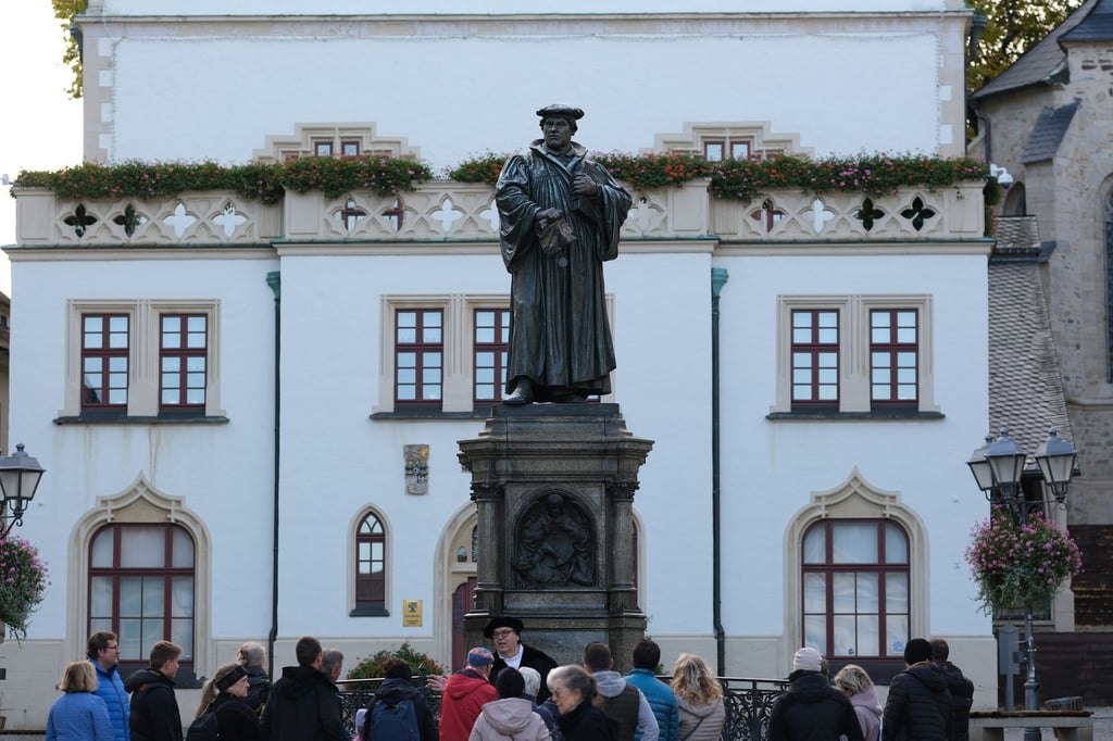 Dirk Wellmitz (M), Stadtführer in der Rolle des Martin Luther, spricht vor dem Luther-Denkmal.