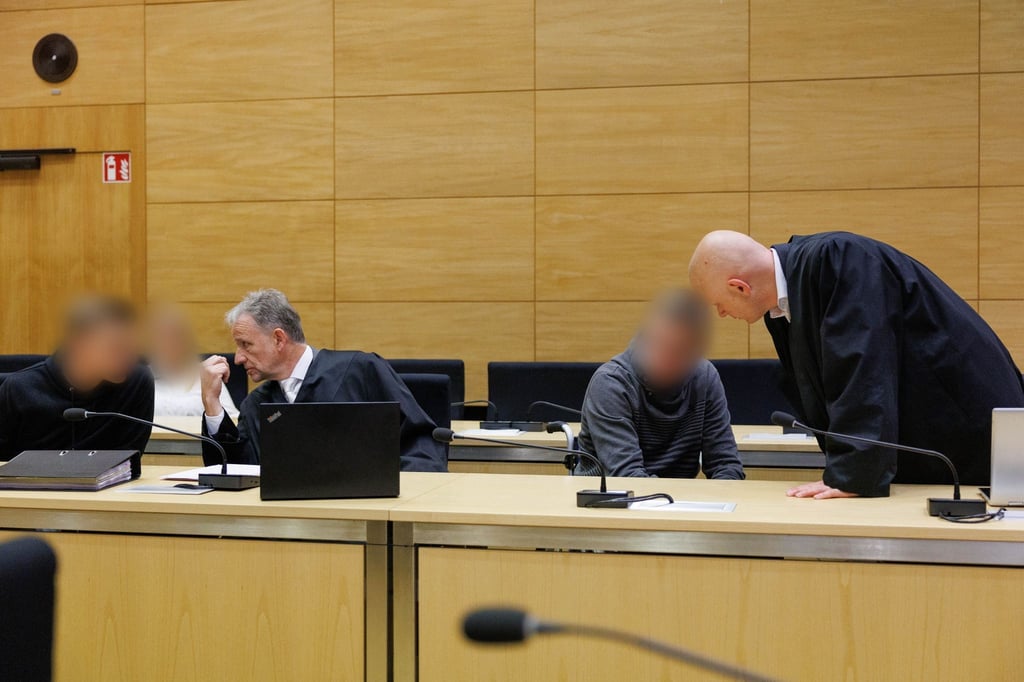 Christian Thüner (2.v.l) und Jerrit Schöll (r), die Verteidiger der Angeklagten, sprechen mit ihren Mandanten in einem Saal des Landgericht Bielefeld zum Auftakt im Prozess um ein illegales Motorradrennen mit Todesfolge.