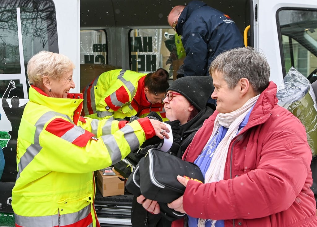 Die ASB-Mitarbeiterin Sonja Diehl (l-r) verteilt an Betty und Conny bei einer Kältehilfe-Aktion Schlafsäcke und Pflege-Sets für Obdachlose und wohnungslose Menschen vor der Suppenküche der Volkssolidarität Potsdam.