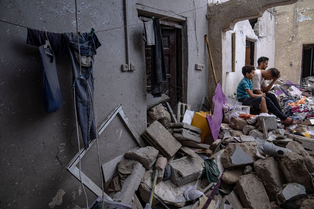 Nachdem es von einem israelischen Luftangriff getroffen wurde, sitzen Palästinenser auf den Trümmern eines Hauses Chan Junis.