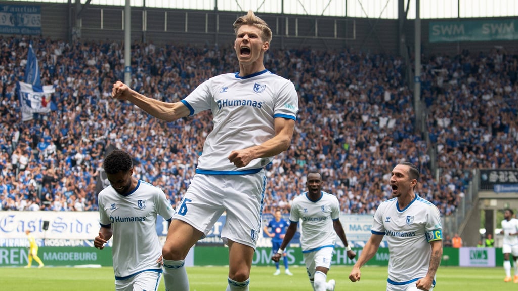 Luca Schuler (M.) und seine Teamkameraden vom 1. FC Magdeburg wollen in die 3. Runde des DFB-Pokals. Dafür müssen sie gegen Holstein Kiel gewinnen.