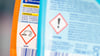 Ätzend und gefährlich: Hinweiszeichen auf Putzmittelverpackungen informieren über potenziell gefährliche Inhaltsstoffe.