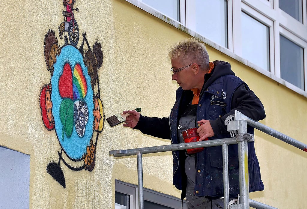 Airbrush-Künstlerin Kerstin Ziegner hat Logo und Namen der neuen Hettstedter Kita „Weltentdecker“ an die Fassade gebracht.