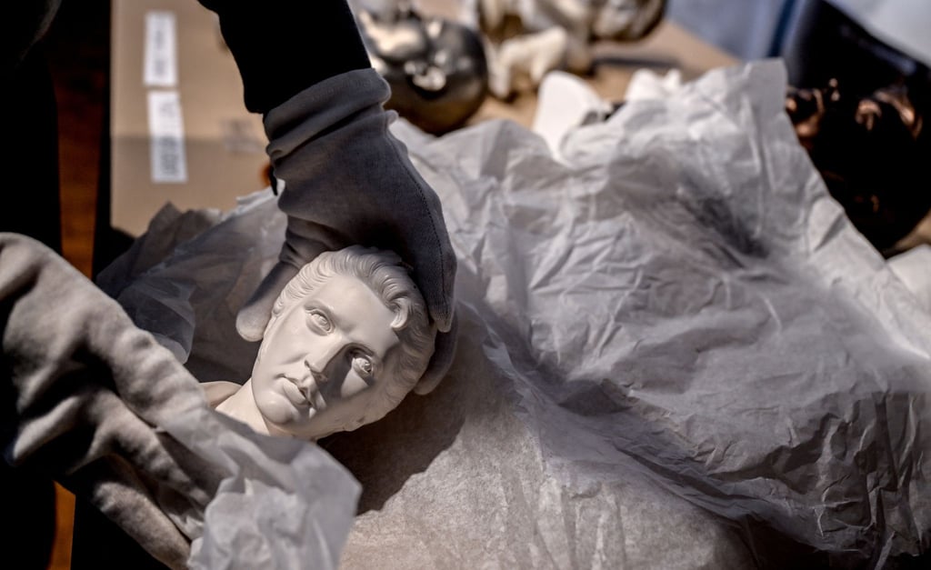 Museumsmitarbeiter Emil packt vor dem Umzug des Museums der Dinge - Werkbundarchiv, das Exponat einer Elvis Büste ein.