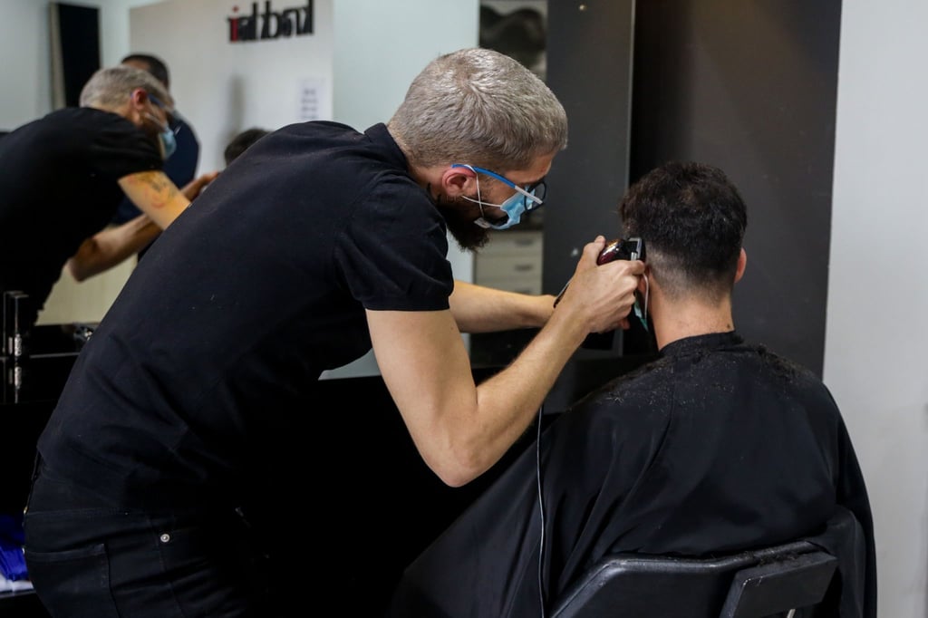 Ein Friseur schneidet einem Kunden die Haare: Edgar Cut erwünscht?