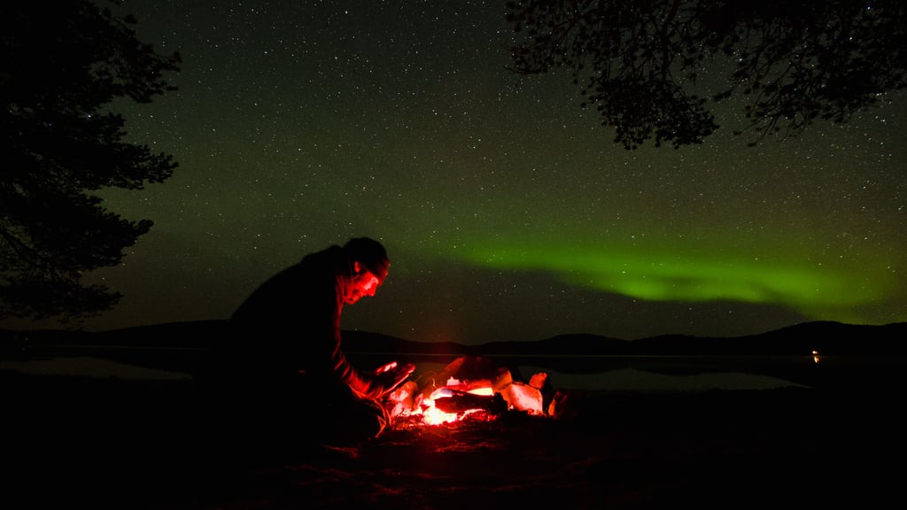 Der Abenteurer, Reise-Führer und Minimalist Dominik Brandt aus Burg an einem See im finnischen Lappland. Bei der Zubereitung seines Essens wurde er von Polarlichtern überrascht.
