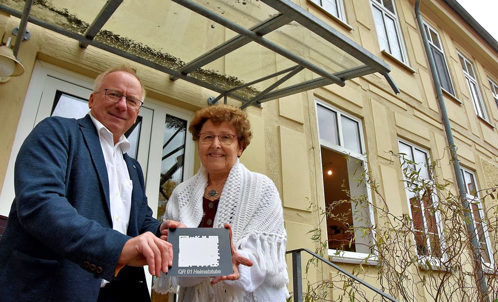 Christa Merker vom Heimatverein und Bernd Fritzsche zeigen die erste Tafel. Die Schilder aus Metall sind von der Firma Giggel gesponsert. Auf einer digitalen Landkarte sollen dann alle QR-Stationen gekennzeichnet werden.