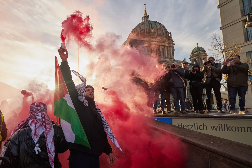 Teilnehmer einer Pro-Palästina-Kundgebung auf der Straße Unter den Linden zünden Pyrotechnik.