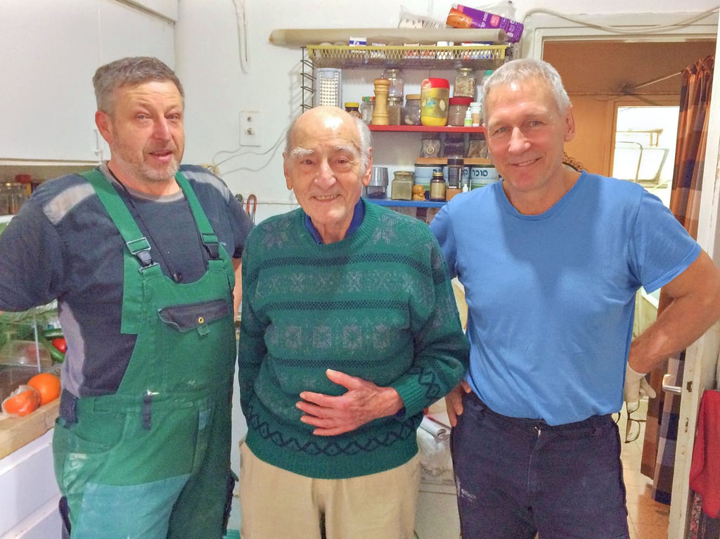 Gärtner Uwe Wenzel (von links), Isachar Ilan und Handwerker Uwe Pfennighaus stehen zusammen in der Wohnung des Holocaust-Überlebenden Ilan. Der sächsische Freundschaftsverein leistet einen kleinen Beitrag: Handwerker renovieren in Israel gratis die Wohnungen von Holocaust-Überlebenden.