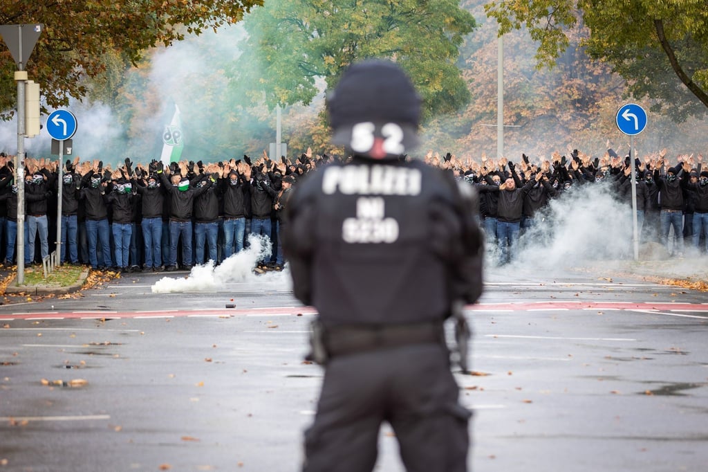 Vor dem Niedersachsen-Derby in Hannover beobachtet ein Polizist einen Fanmarsch.