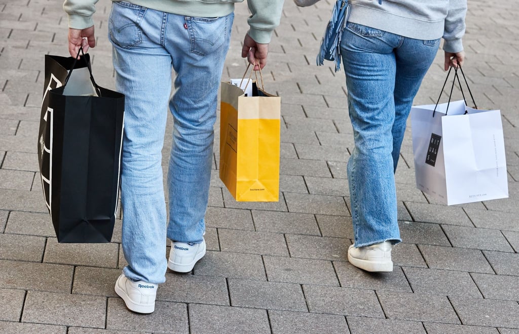 Eine Frau und ein Mann tragen mehrere Einkaufstüten am verkaufsoffenen Sonntag auf der Mönckebergstraße.