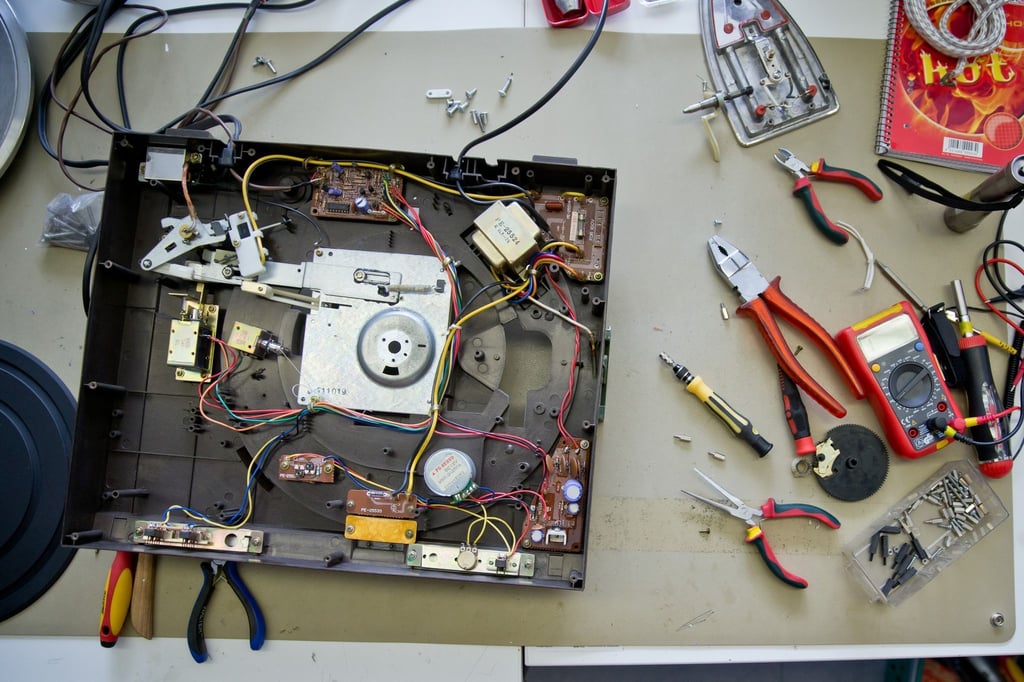 Ein Elektrogerät liegt zur Reparatur geöffnet auf einem Tisch.