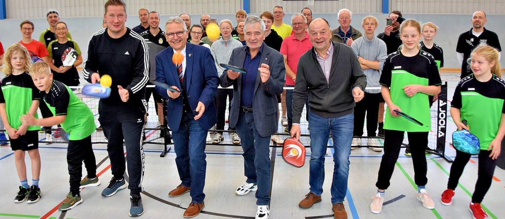 Gemeinsam mit den Kindern vom Team „Ohrehüpfer“ probieren sich CDU-Landtagsabgeordneter Tim Teßmann (vorn; v.l.), Klaus Zimmermann, Staatssekretär im Ministerium für Inneres und Sport, Calvördes stellvertretender Bürgermeister Hubertus Nitzschke und Volker Preetz, Teamleiter vom Netzbetrieb Avacon/Gardelegen, in der Trendsportart Pickleball aus. Der Fußboden der Calvörder Sporthalle wurde zuvor aufgearbeitet und mit neuen Linien versehen.