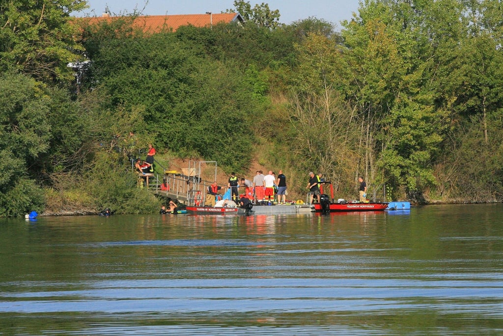 Einsatzkräfte der Feuerwehr stehen am Sundhäuser See.