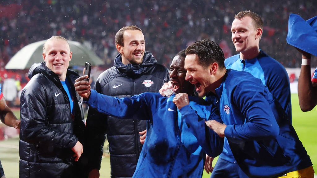 Amadou Haidara und Janis Blaswich feiern den RB-Sieg in Belgrad vor dem Smartphone.