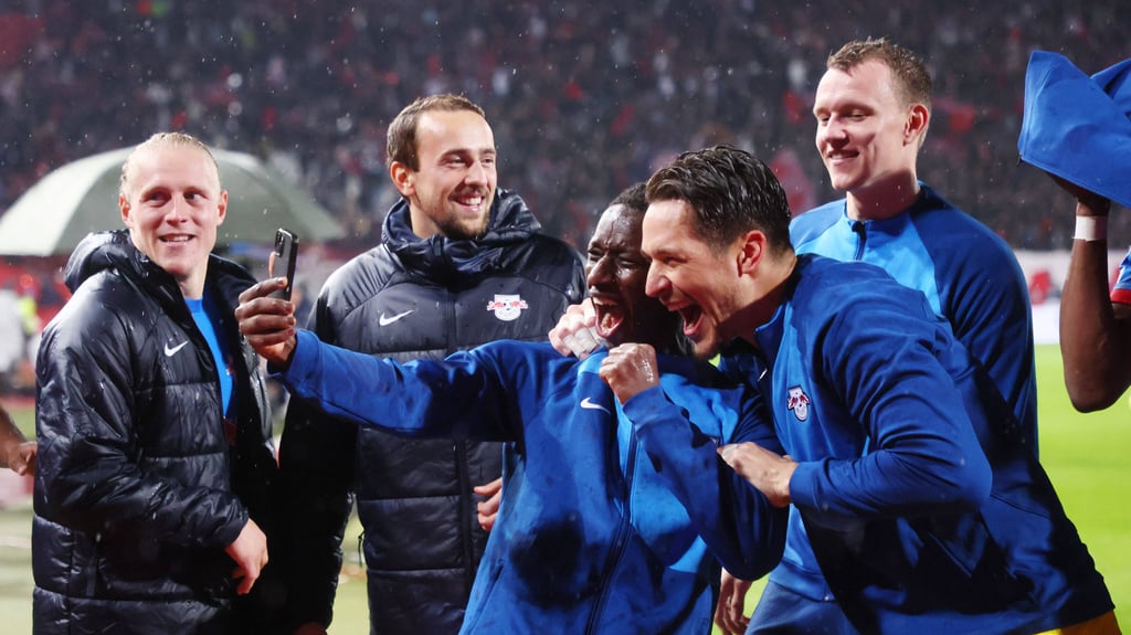 Amadou Haidara und Janis Blaswich feiern den RB-Sieg in Belgrad vor dem Smartphone.