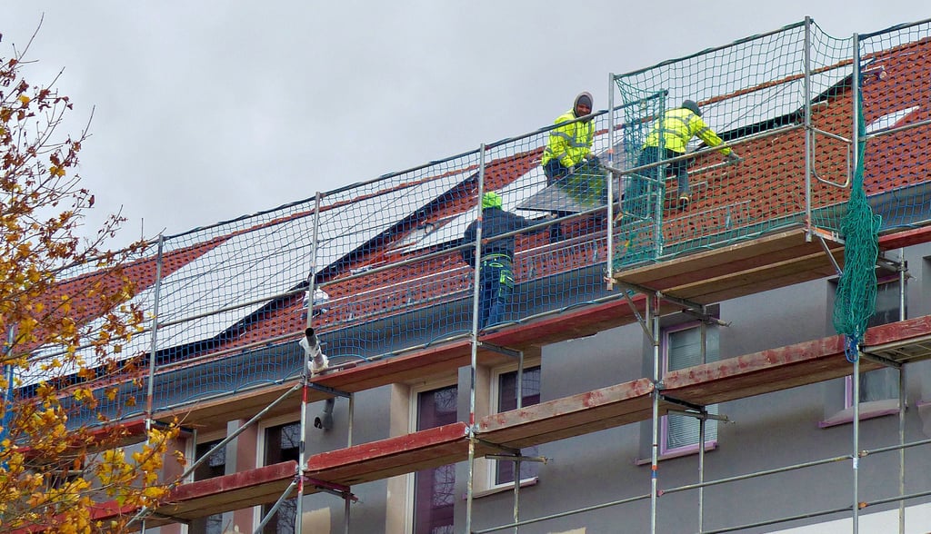 Auf dem Dach des Wohnblocks in der Franz-Mehring-Straße 9 - 15 in Wolfen-Nord werden die Solarmodule durch die Firma Besa montiert.