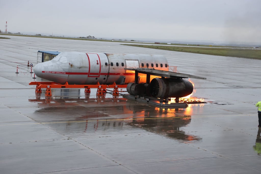 Feuerwehrleute löschen einen simulierten Triebwerksbrand auf dem Rollfeld bei einer Notfallübung am Flughafen Erfurt-Weimar.