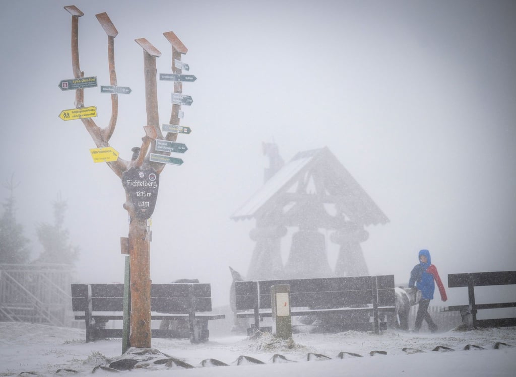 Der mit einer leichten Schneeschicht bedeckte 1215 Meter hohe Fichtelberg liegt im Nebel.