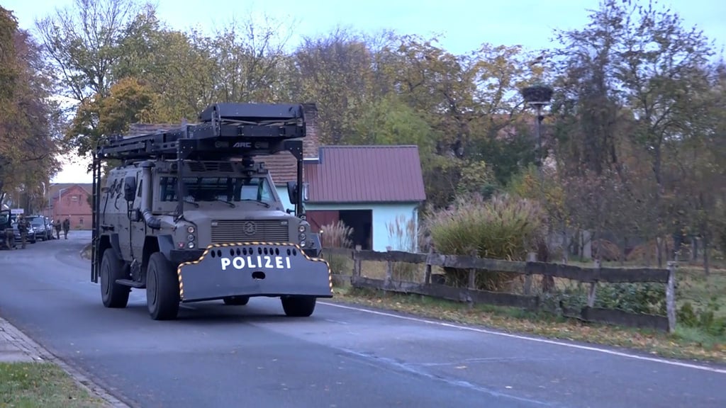 Schweres Gerät eines Spezialeinsatzkommandos der Polizei rollt durch den Ort.