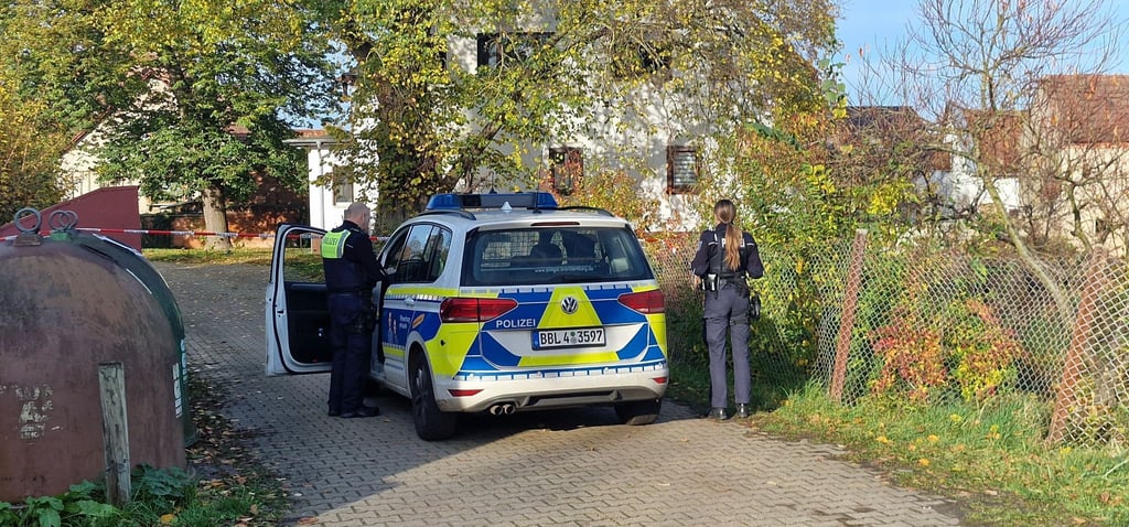 Polizisten stehen nahe des Tatortes.