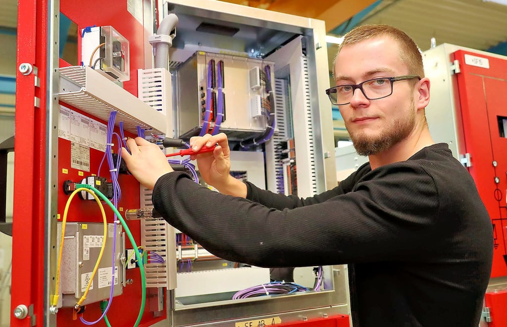 Clemens Jungmann, 21 Jahre, Auszubildender im 3. Lehrjahr als Betriebselektroniker beim Verdrahten eines Schaltschrankes.
