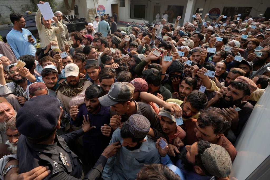 Pakistanische Polizeibeamte versuchen, Einwanderer in Karachi zu kontrollieren. Pakistan hat Tausende afghanische Flüchtlinge abgeschoben.