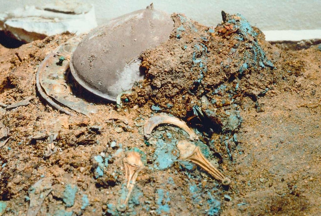 Der Schildbuckel aus dem Fürstengrab von Gommern noch im Erdreich.Gut zu sehen auch die blauen Farbreste.