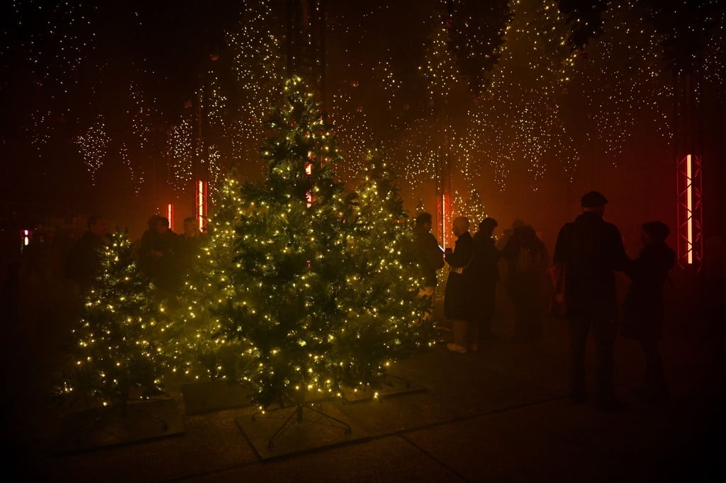 Besucher sehen sich eine Klang- und Lichtinstallation bei der Lichtshow „Winterlights“ im Rahmen der Ausstellung „DARK MATTER“ an.