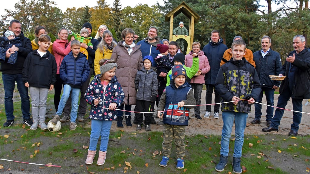 Drei Kinder dürfen mit Scheren das bunte Band zur symbolischen Freigabe des Spielplatzes durchschneiden. Es ist das erste öffentliche Spielareal für Berenbrock. Jetzt haben alle elf Ortsteile der Gemeinde Calvörde einen oder manche Orte sogar zwei Plätze zum Toben.