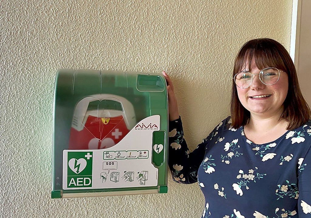 Bereichsleiterin Bianca Steiner am Defibrillator, der für Notfälle im Sankt-Pia-Heim öffenltich zugänglich ist. Bei Bedarf kann hierfür jeder Mitarbeiter im Haus angesprochen werden.