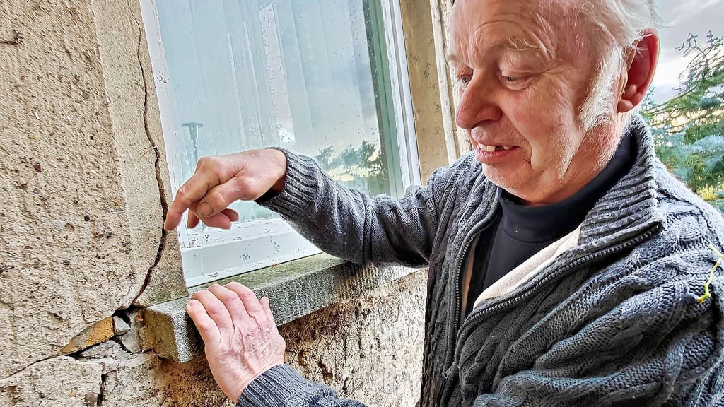 Lutz Jüngling zeigt die Schäden an seinem Vorbau. Am Fenster ist der Riss besonders groß.