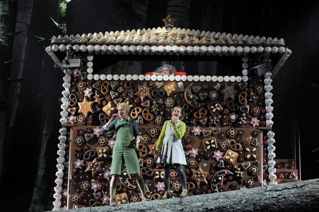 Hänsel und Gretel knuspern in Magdeburg am Pfefferkuchenhäuschen.