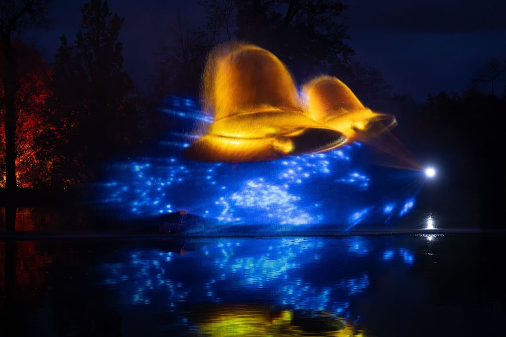 Glocken werden im Lustgarten zur Eröffnung des Lichterzaubers „Christmas Garden“ in den Anlagen von Schloss Pillnitz östlich von Dresden in eine Wasserfontäne projeziert.