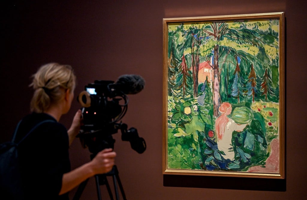 Eine junge Frau filmt das Gemälde „Frau mit Kürbis“ des Malers Edvard Munch.